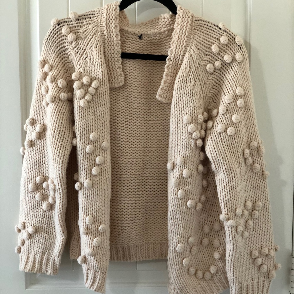 Pink/beige cardigan sweater with heart detail.